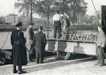 405950 Afbeelding van het lossen van een schip van rederij De Tijdgeest met baren zilver, op de Muntkade te Utrecht, ...